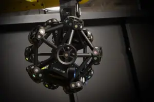 A black spherical robotic mechanism built from interlocking circular joints and rings.