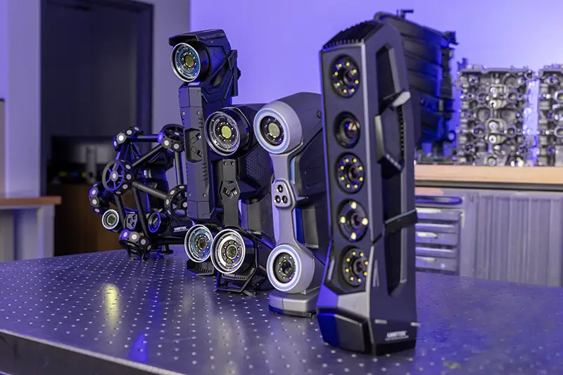 Multi-pulley belt drive rig mounted on a perforated metal workbench under blue lighting.